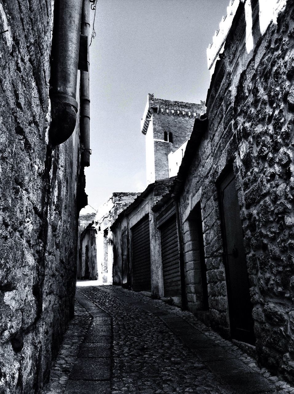 architecture, built structure, building exterior, the way forward, diminishing perspective, narrow, clear sky, low angle view, history, building, alley, day, sky, no people, street, outdoors, shadow, vanishing point, sunlight, long