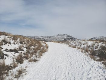 Snow covered land against sky