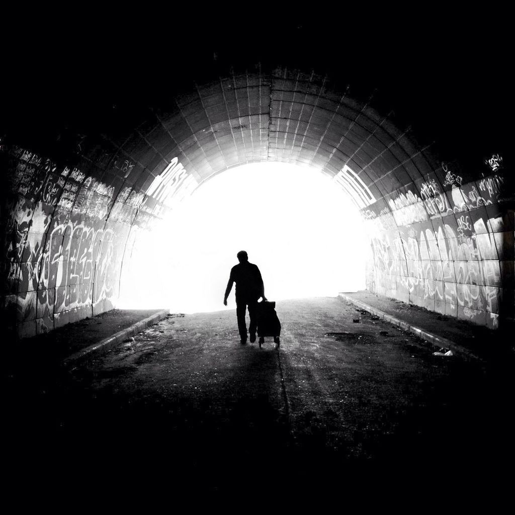 indoors, tunnel, full length, lifestyles, rear view, men, silhouette, leisure activity, walking, arch, the way forward, sunlight, standing, built structure, person, architecture, light at the end of the tunnel