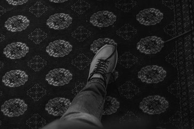 Low section of man standing on tiled floor