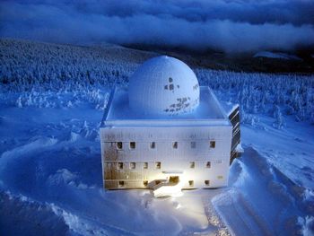 Aerial view of snow covered field against sky