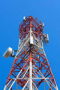 Low angle view of communications tower against clear blue sky