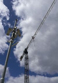 Low angle view of crane against sky