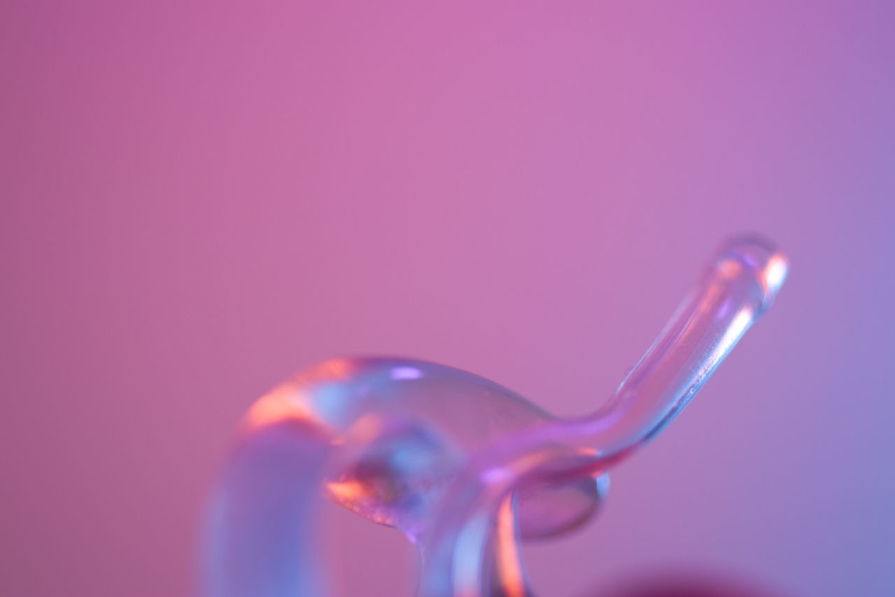 CLOSE-UP OF WATER DROPS ON PINK OVER COLORED BACKGROUND