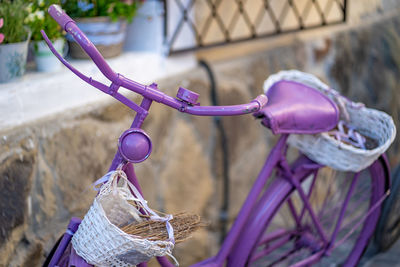 High angle view of bicycle with basket parked against wall