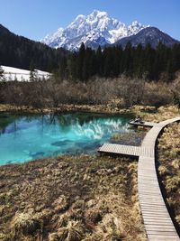 Scenic view of lake by snowcapped mountains against sky