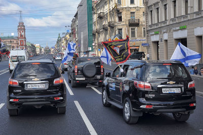 Cars on city street by buildings