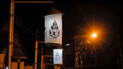 Low angle view of illuminated lighting equipment at night