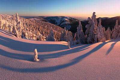 Panoramic view of snowcapped mountains against sky during sunset