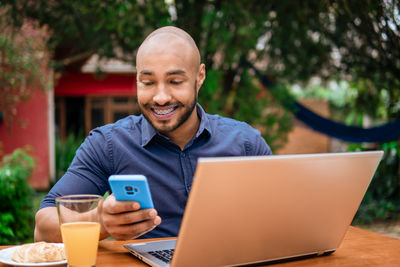 Portrait of man using laptop while sitting on table