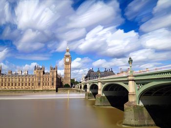 Bridge over river against cloudy sky