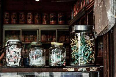 Objects in glass jar at shop for sale