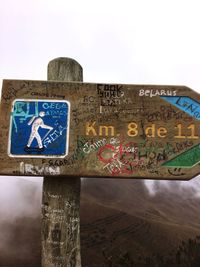 Close-up of road sign against sky