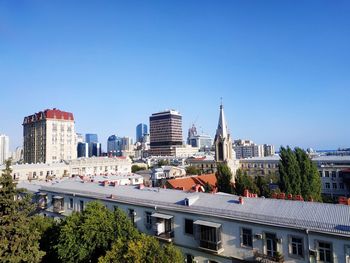 Buildings in city against clear blue sky