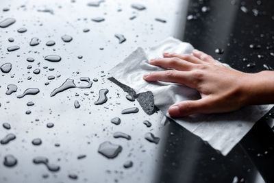 Close-up of person hand holding wet paper