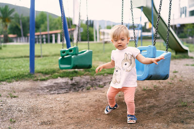 Girl playing on swing in playground