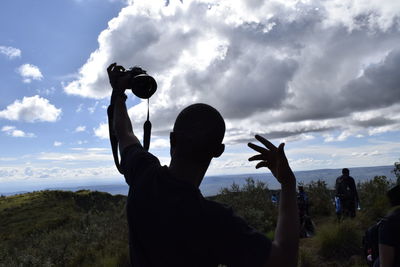 Silhouette of woman against cloudy sky