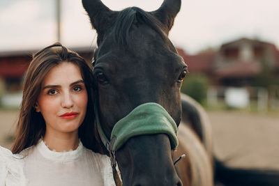 Portrait of young woman with horse