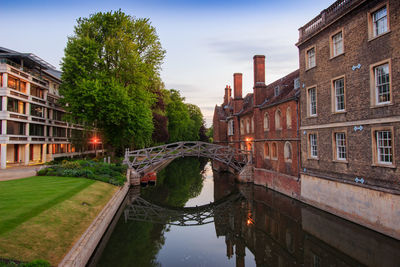 Bridge over canal amidst buildings in city against sky