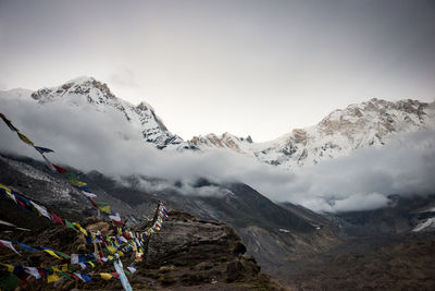 Prayer flags hanging over mountains against sky