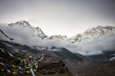 Prayer flags hanging over mountains against sky