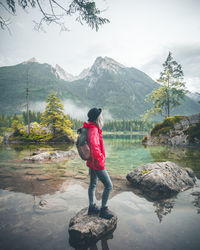 Woman looking at lake against mountains