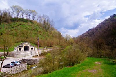 Arch bridge amidst trees against sky