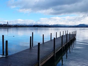 Wooden pier on lake against sky