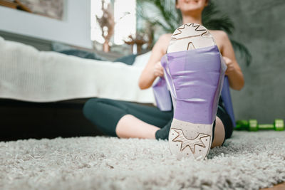 Close up of the cheerful sporty woman with black hair stretches to the leg 