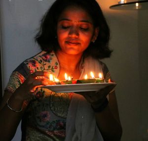 Close-up of man with burning candle