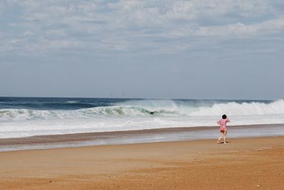 Man standing on beach against sky