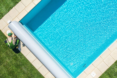 High angle view of repairman working by swimming pool