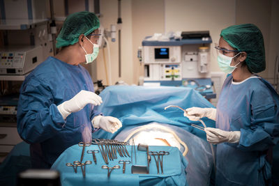 Surgeons performing operation on patient at hospital