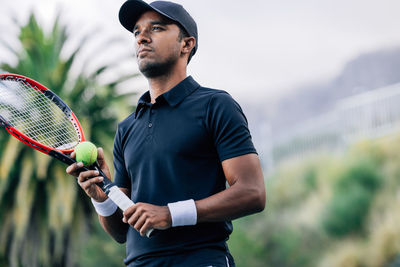 Midsection of man playing tennis