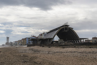 Exterior of old building by beach against sky