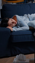 Woman sleeping on sofa at home