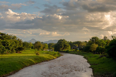 Scenic view of farm against sky during sunset