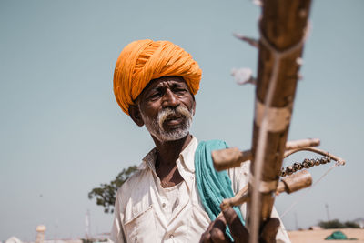 Man holding umbrella against sky