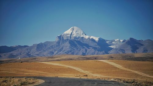 Scenic view of snowcapped mountains against clear blue sky