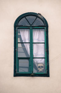 Close-up of window with skull