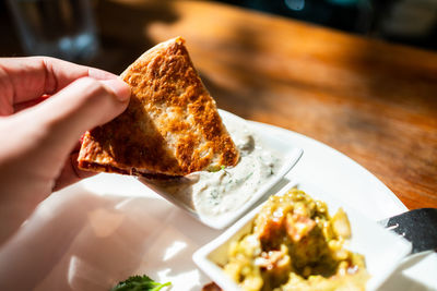 Close-up of hand holding food in plate