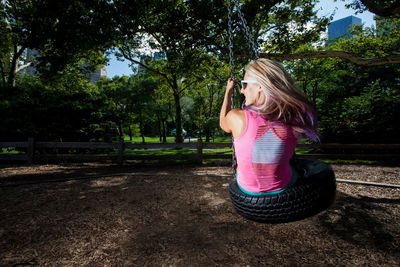 Rear view of woman on swing at park