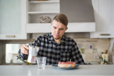 Portrait of young man sitting on table