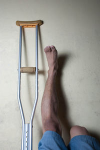 Low section of handicapped man with crutch on floor