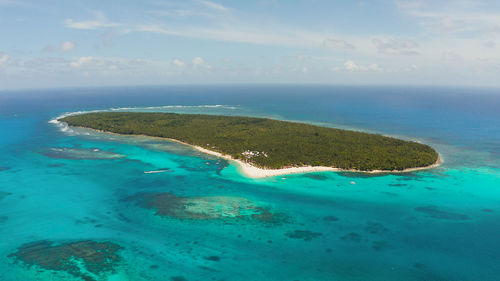 Sandy beach on a tropical island by coral reef atoll from above. daco island,