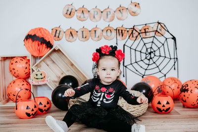 Beautiful one year old caucasian girl in halloween costume at home with halloween concept 
