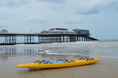 Pier on beach against sky