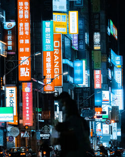 Information sign on illuminated street in city at night