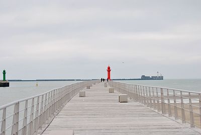 Rear view of pier on sea against sky