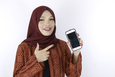 Young woman using smart phone against white background